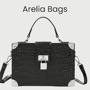 Peut inclure: Sac à main rectangulaire noir avec une texture crocodile, des garnitures argentées et une poignée supérieure. Le sac est doté d'une bandoulière et d'une fermeture à cadenas. Le texte "Arelia Bags" est en haut.