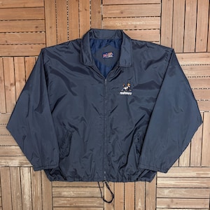 May include: Navy blue windbreaker jacket with a full zipper closure, two front pockets, and a drawstring at the hem. The jacket features a small embroidered logo on the chest and the text "Roadrunners".