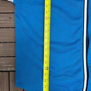 May include: A blue mesh baseball jersey with white sleeves and a white stripe down the front. A yellow tape measure shows the length of the jersey, measuring approximately 30 inches.
