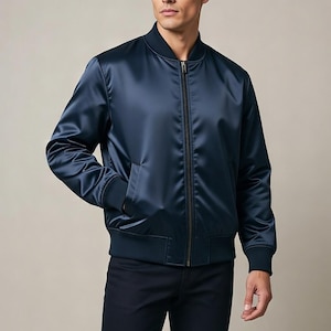 Pode incluir: Casaco bomber azul marinho em cetim brilhante. O casaco tem fecho de correr inteiro, punhos e bainha canelados. Dois bolsos frontais completam o design clássico.