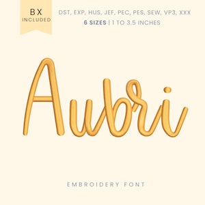 May include: A golden-yellow script font spelling "Aubri" is displayed on a cream background. The text is 3D-rendered, with the words "BX INCLUDED" in a banner at the top left. The text "6 SIZES | 1 to 3.5 inches" is above the name, and "EMBROIDERY FONT" is below.