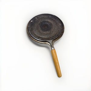 May include: A white ceramic mug with a black handle and the text "But First, Coffee" in a bold, black font. The mug is set against a blurred background, suggesting a cozy setting. The mug appears to be approximately 4 inches tall.