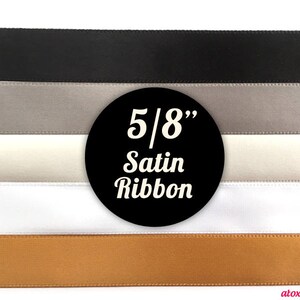 May include: Five different colours of 5/8 inch satin ribbon. The colours are black, grey, white, ivory, and gold.