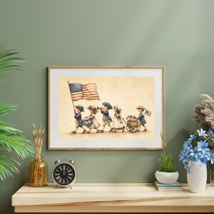 Op de afbeelding: Een ingelijste print met een aquarelillustratie van vijf kinderen in koloniale kleding die in een optocht marcheren. E&eacute;n kind draagt een grote Amerikaanse vlag, een ander bespeelt een trommel, &eacute;&eacute;n blaast op een hoorn en &eacute;&eacute;n trekt een houten wagentje.