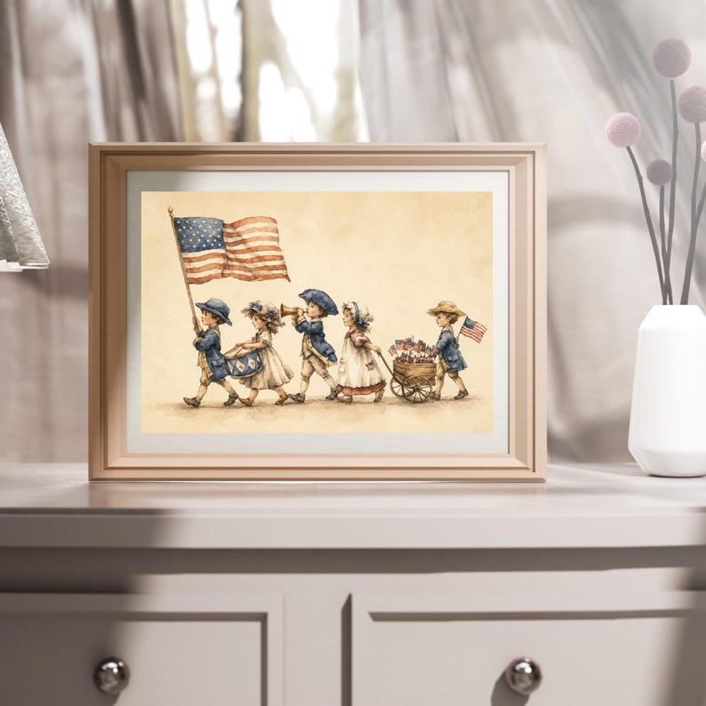 Op de afbeelding: Een ingelijste print met een aquarelillustratie van vijf kinderen in historische kleding die in een parade marcheren. De kinderen dragen een Amerikaanse vlag, spelen op een trommel en hoorn, en trekken een houten kar vol kleine vlaggetjes op een beige achtergrond.