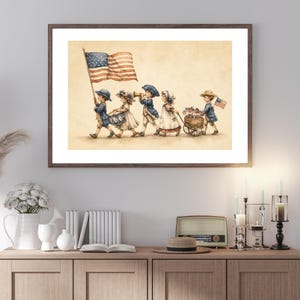 Op de afbeelding: Een ingelijste print in aquarel-stijl met vijf kinderen in historische kleding die in een optocht lopen. E&eacute;n kind draagt een grote Amerikaanse vlag, een ander bespeelt een trommel, &eacute;&eacute;n speelt een hoorn en de laatste trekt een houten kar vol kleine vlaggetjes.