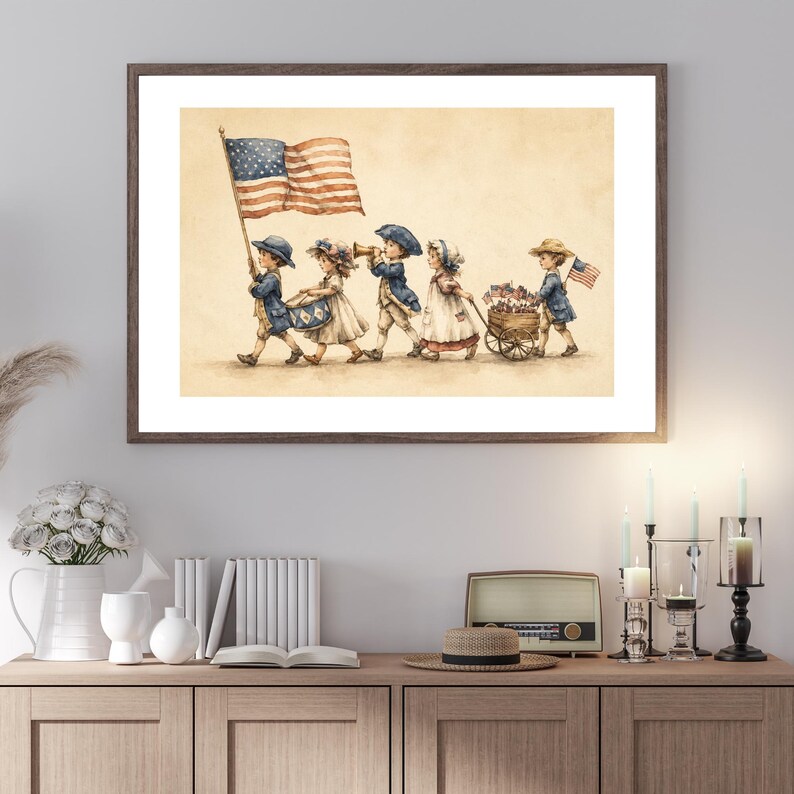 Op de afbeelding: Een ingelijste print in aquarel-stijl met vijf kinderen in historische kleding die in een optocht lopen. E&eacute;n kind draagt een grote Amerikaanse vlag, een ander bespeelt een trommel, &eacute;&eacute;n speelt een hoorn en de laatste trekt een houten kar vol kleine vlaggetjes.