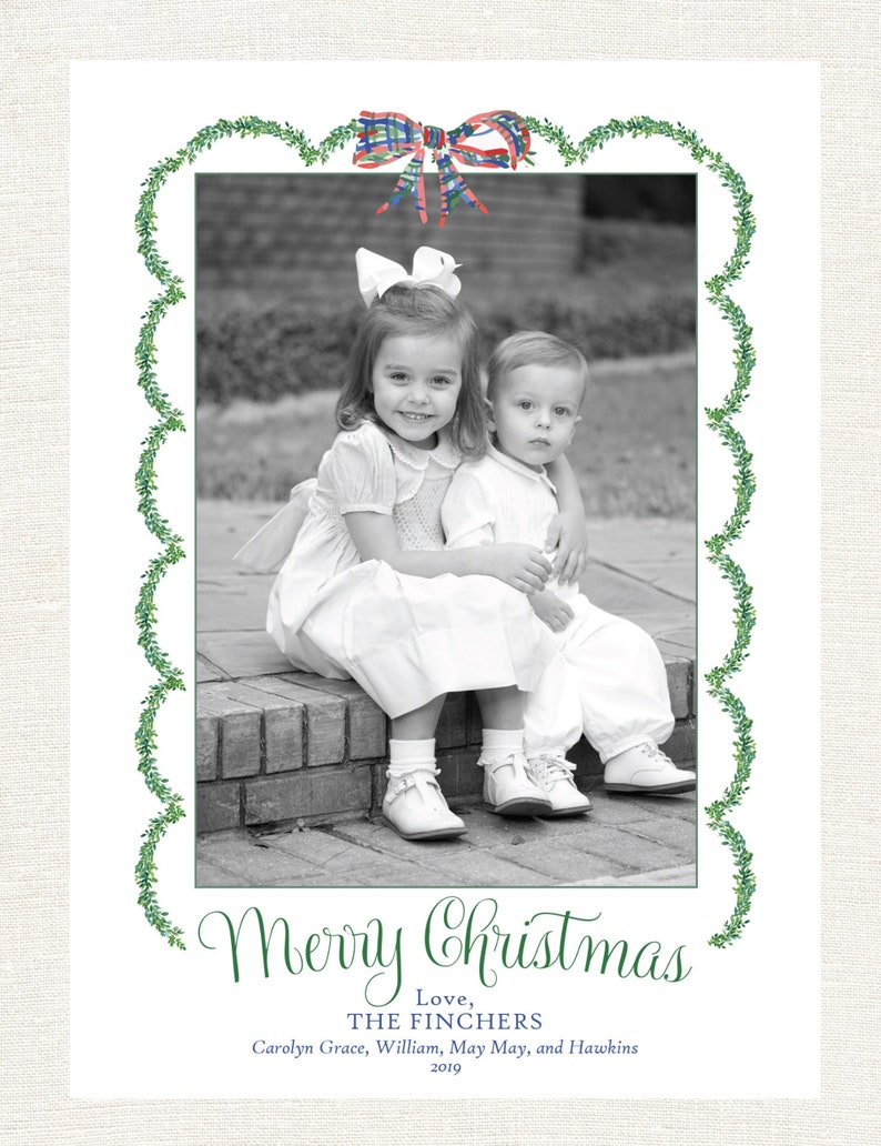May include: Christmas card with a black and white photo of two children. The card has a green border with a watercolor bow at the top. The text "Merry Christmas" is written in green script, along with names and the year 2019.
