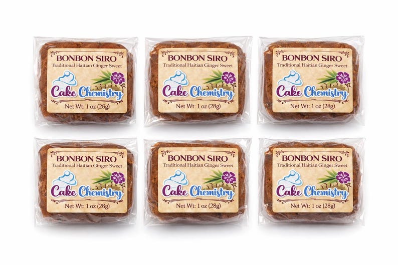 May include: Six individually wrapped Bonbon Siro, a traditional Haitian ginger sweet, each with a label featuring the text "Cake Chemistry." Each sweet weighs 28g. The labels include a graphic of a cupcake, ginger, and a purple flower.