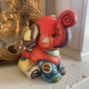 May include: A set of three ceramic mugs with a speckled, matte finish. The mugs are in shades of cream, light brown, and dark brown. Each mug has a simple, minimalist design, perfect for coffee or tea.