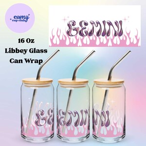 Op de afbeelding: Drie heldere Libbey-glazen met bamboe deksels en metalen rietjes. Elk glas heeft het woord "GEMINI" in een metallic paarse lettertype over een roze vlammenontwerp. De glazen zijn 473 ml.