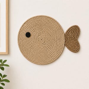 Pu&ograve; includere: Un pesce decorativo fatto di corda arrotolata, con un corpo circolare e una pinna caudale a forma di cuore. Il pesce ha un occhio circolare nero. La corda &egrave; di colore marrone naturale, creando un'estetica rustica e nautica.