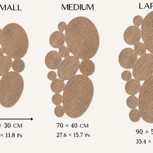 May include: Three wall art pieces made of coiled tan rope in small, medium, and large sizes. The small piece measures 19.7 x 11.8 inches, the medium 27.6 x 15.7 inches, and the large 35.4 x 21.7 inches. Each features a cluster of circular shapes.