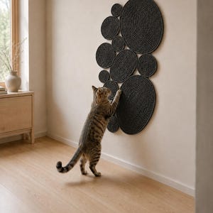 May include: A wall-mounted cat scratching post consisting of multiple dark gray circular and oval discs arranged in a cluster. The discs feature a coiled rope texture. A tabby cat is standing on its hind legs, scratching the surface of the discs.