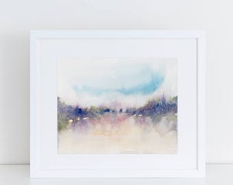 May include: A framed watercolor painting with a landscape scene. The artwork features soft blues, purples, and pinks, creating a dreamy, atmospheric effect. The white frame adds a clean, modern touch to the art piece.