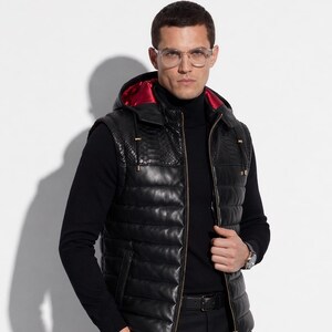 Könnte beinhalten: Schwarze Lederweste mit Kapuze, gestepptem Design und rotem Satinfutter. Die Weste hat ein Schlangenmuster auf den Schultern und einen goldenen Reißverschluss. Das Model trägt einen schwarzen Rollkragenpullover und eine schwarze Hose.