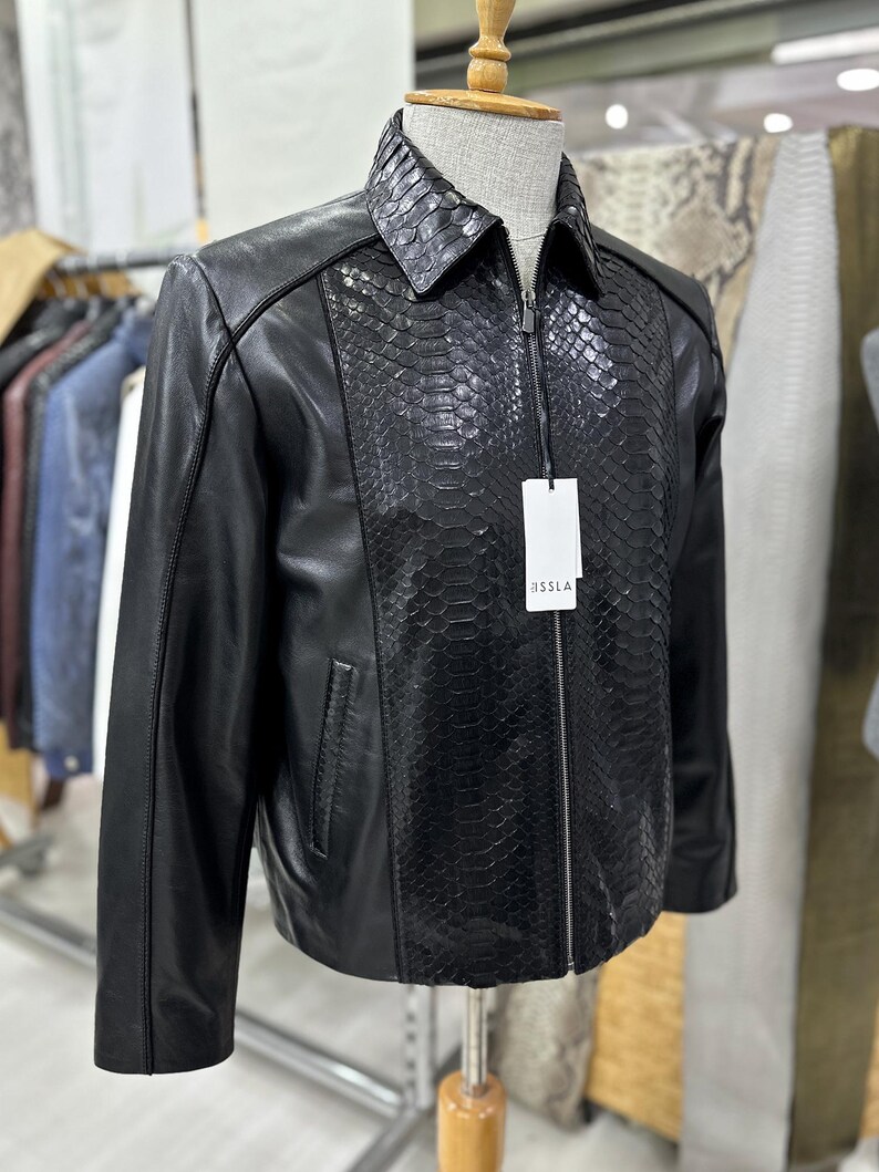 Peut inclure: Une tasse en c&eacute;ramique blanche avec une anse noire et le texte "But First, Coffee" en noir, en gras. La tasse est pos&eacute;e sur une surface blanche. La tasse mesure environ 10 cm de haut.