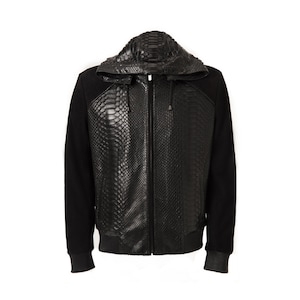 May include: Black hooded jacket with a snakeskin-textured front panel and hood. The jacket features black sleeves and a ribbed hem and cuffs. The zipper runs down the centre of the jacket. The jacket is displayed against a white background.