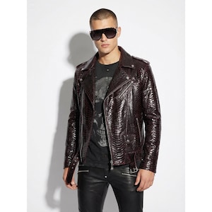 以下が含まれることがあります： ヘビ革風の質感のバーガンディ色のレザージャケット。ジャケットは、クラシックな非対称ジッパー、複数のポケット、ノッチカラーが特徴です。モデルは黒いサングラスと黒いTシャツを着ています。