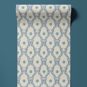May include: A roll of wallpaper featuring a repeating pattern of blue leaves and white stars on a cream background.