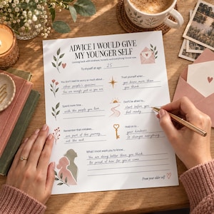 Op de afbeelding: Een wit vel papier met de titel Advice I Would Give My Younger Self met gedrukte prompts en handgeschreven antwoorden. Het document bevat botanische illustraties, een ster, een zon en een sleutelpictogram, met een gouden pen op de pagina.