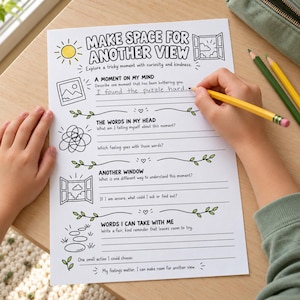 May include: A white worksheet titled Make Space for Another View with black line art illustrations including a sun, a window, and a tangled knot. The page features prompts for writing reflections, with the handwritten text I found the puzzle hard.
