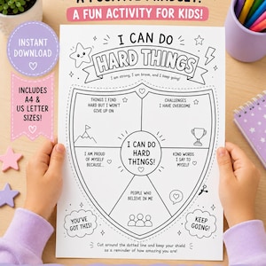 Op de afbeelding: Een wit printbaar activiteitenblad met een schildafbeelding en de tekst I CAN DO HARD THINGS. Het werkblad bevat secties voor het noteren van uitdagingen, sterke punten en ondersteuningssystemen, versierd met sterren, een trofee en een berg.