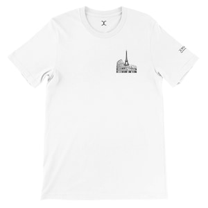 May include: White t-shirt featuring a black graphic of the Eiffel Tower and the Colosseum. The shirt has a crew neck and short sleeves. The brand logo is on the sleeve.