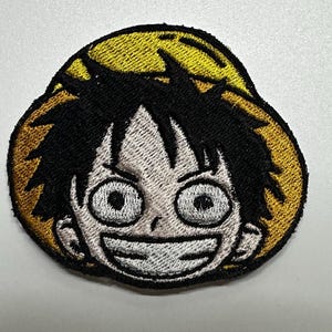 Broderad lapp med halmhatt och piratmotiv – i mangastil