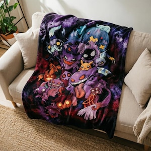 May include: A soft throw blanket featuring a vibrant, dark-themed graphic print of various purple and black ghost-type creatures. The design includes a central grinning purple character with a long tongue, surrounded by smaller figures on a nebula background.