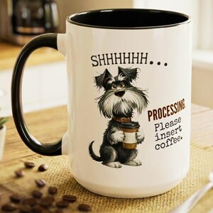 May include: White ceramic coffee mug with a black handle and rim. The mug features a cartoon illustration of a Schnauzer dog holding a coffee cup, with the text "SHHHHH... PROCESSING Please insert coffee."