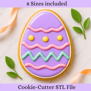 Könnte beinhalten: Ein Osterei-Ausstecher mit einem lila Zentrum, verziert mit rosa und grünen Wellenlinien und gelben Punkten. Der Text "8 Sizes included" steht oben und "Cookie-Cutter STL File" unten. Der Ausstecher hat einen hellbraunen Rand.