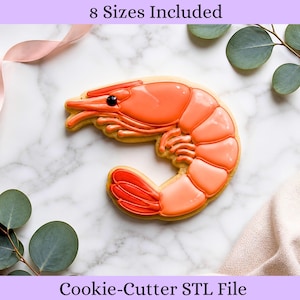 May include: A shrimp-shaped cookie cutter with orange icing details and a black eye. The cookie cutter is on a marble surface, with the text "8 Sizes Included" and "Cookie-Cutter STL File".