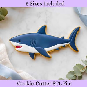 May include: A shark-shaped cookie cutter with a dark blue top, white underbelly, and red mouth detail. The text 8 Sizes Included and Cookie-Cutter STL File is visible at the top and bottom of the image, indicating a digital file for 3D printing.