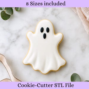 May include: A ghost-shaped biscuit with smooth white icing and three small black oval accents forming eyes and a mouth. The text 8 Sizes included and Cookie-Cutter STL File is displayed at the top and bottom of the image respectively.