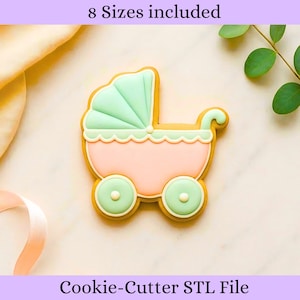 May include: A baby carriage cookie cutter in a pastel color scheme. The carriage is pink with a mint green hood and wheels. The text "8 Sizes included" and "Cookie-Cutter STL File" are displayed.