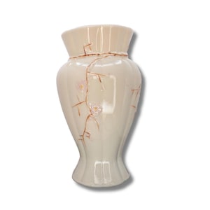 May include: A cream ceramic vase with a flared top and a narrow base. It has a delicate floral design in pink and brown, with vertical ridges and a crackled effect. The vase is approximately 25 cm tall.