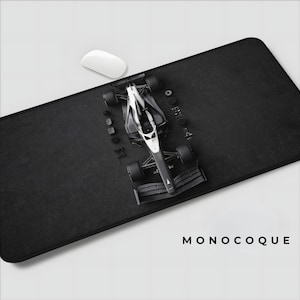 May include: A black rectangular mousepad with a white computer mouse and a model race car. The race car is black and white. The word "MONOCOQUE" is printed in white on the bottom right.