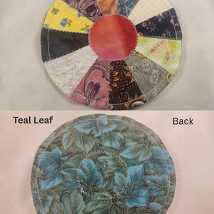May include: A handmade, circular coaster with a patchwork design on the front, featuring various fabric patterns and colors. The center is a solid red-orange. The back has a teal leaf pattern. The text "Front", "Teal Leaf", and "Back" are visible.