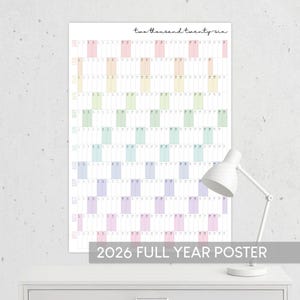 Peut inclure: Un calendrier mural complet pour l'année 2026, de conception minimaliste. Le calendrier présente un code couleur pastel pour chaque mois, avec le texte "two thousand twenty six" en haut. Le texte "2026 FULL YEAR POSTER" est en bas.