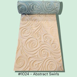 May include: A light blue roller with an abstract swirl pattern is positioned above a beige surface with a matching embossed design. The image includes the text "#1024 - Abstract Swirls". The roller and surface are likely used for decorative purposes.