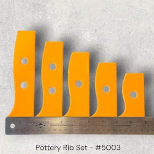 May include: An orange pottery rib set with a curved design and a hole. The set includes five ribs of varying sizes, arranged from largest to smallest. A metal ruler is placed below the ribs. The text "Pottery Rib Set - #5003" is at the bottom.