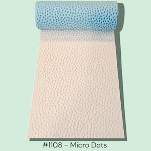 May include: A rolled-up blue perforated foam material sits atop a beige, dotted foam sheet. The beige sheet is unrolled, revealing a textured surface. The text "#1108 - Micro Dots" is at the bottom.