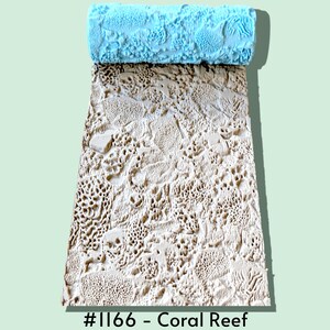 May include: A light blue cylindrical texture roller with a raised coral reef pattern, shown with a beige rectangular impression of the same design. The text #1166 - Coral Reef is printed at the bottom of the image, indicating the specific pattern.