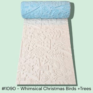 May include: A light blue rolling pin with a whimsical Christmas design, featuring birds and trees, is shown above a sheet with the same embossed pattern. The text at the bottom reads "#1090 - Whimsical Christmas Birds + Trees."