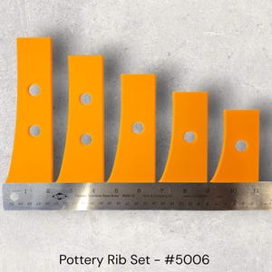 May include: Five orange pottery ribs of different sizes, each with a curved edge and a circular hole. The ribs are arranged in descending order next to a ruler. The text "Pottery Rib Set - #5006" is at the bottom. Measurements are in inches.