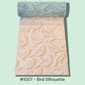 May include: A light blue rolling pin with a bird pattern is shown partially rolled out on a white surface with the same bird design. The text "#1007 - Bird Silhouette" is at the bottom.
