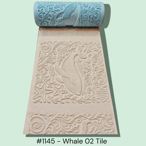 May include: A light blue rolling pin with a whale and starfish design. The rolled-out pattern features a whale, starfish, and seashell design. The text at the bottom reads "#1145 - Whale O2 Tile".