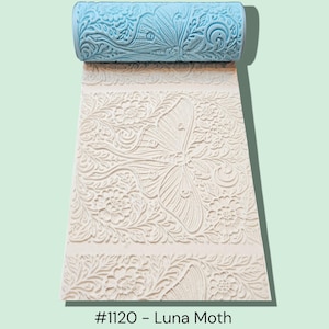 May include: A light blue and white roller with a butterfly and floral pattern, unrolled to reveal the embossed design. The text "#1120 - Luna Moth" is at the bottom of the image. The roller is designed for creating textured surfaces.