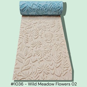 May include: A light blue textured roller with a floral design, alongside a cream-colored surface embossed with a matching pattern of wild meadow flowers and foliage. The text at the bottom reads "#1036 - Wild Meadow Flowers 02".